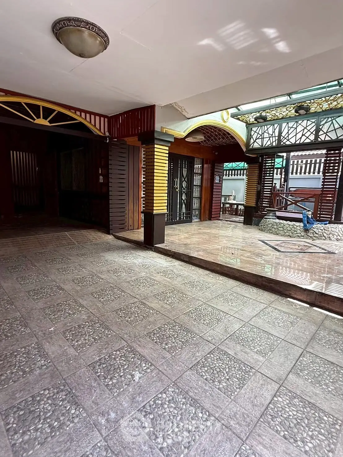 Spacious tiled entrance with decorative columns and natural light