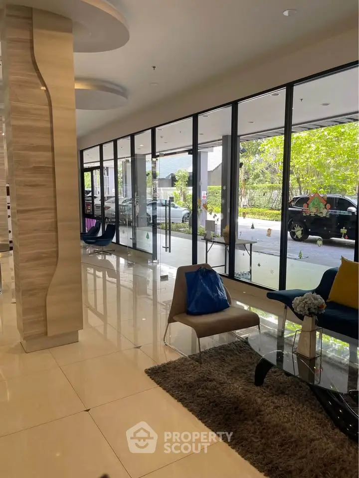 Modern building entrance with sleek glass doors and stylish seating area.