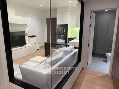 Modern apartment interior with open living room and kitchen, featuring sleek furniture and contemporary design.