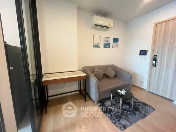 Modern living room with cozy gray sofa, stylish decor, and air conditioning in a contemporary apartment.