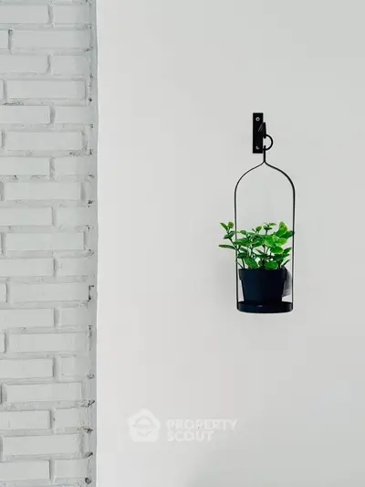 Minimalist wall decor with hanging plant on white brick wall