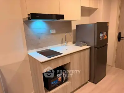 Modern kitchen with sleek appliances and stylish cabinetry in a compact layout.