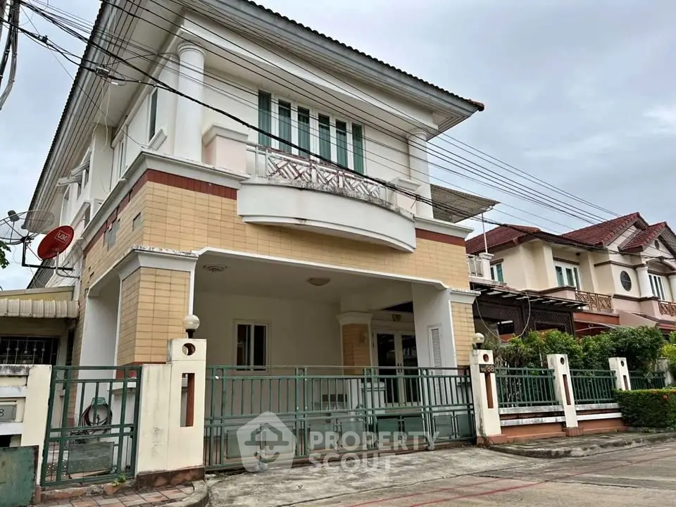 Charming two-story house with gated entrance and classic architectural design in a serene neighborhood.