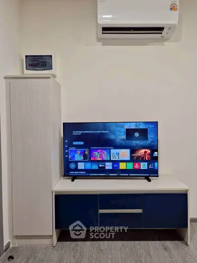 Modern living room with sleek TV unit and air conditioning, perfect for cozy entertainment.