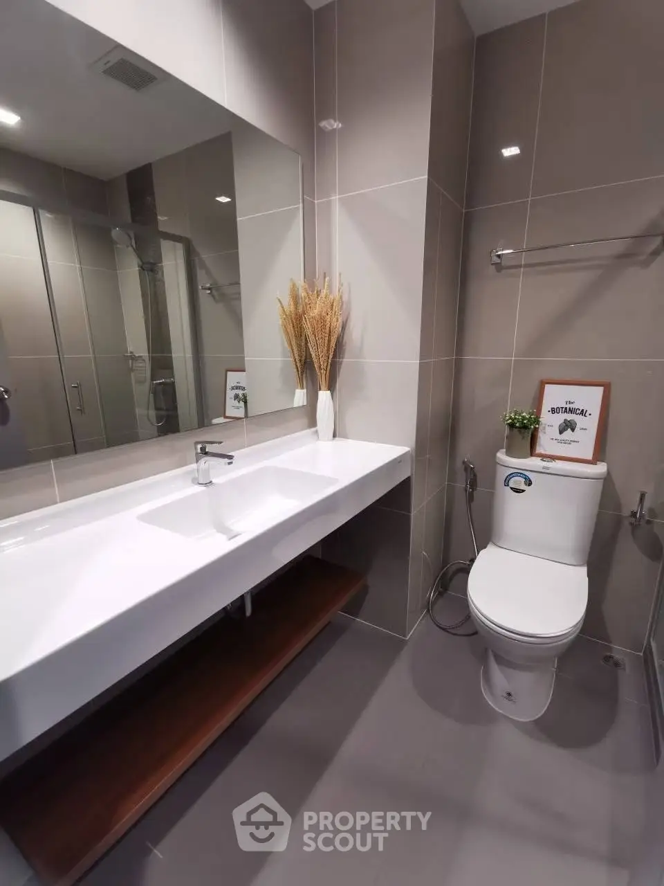 Modern bathroom with sleek design, featuring a large mirror and elegant fixtures.
