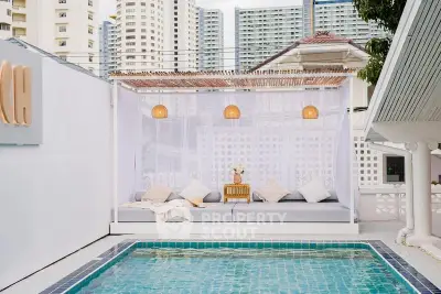 Luxurious poolside cabana with modern cityscape backdrop, perfect for relaxation and entertainment.