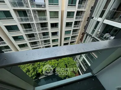 Stunning high-rise balcony view overlooking lush greenery and modern architecture.