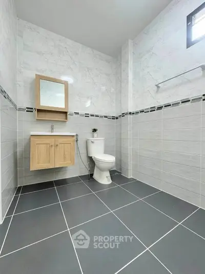 Modern bathroom with sleek tiles and wooden vanity