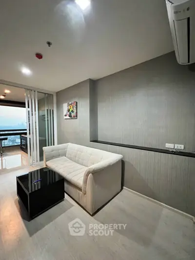 Modern living room with sleek design and balcony view in a high-rise apartment.