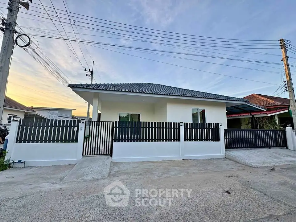 Charming single-story house with modern fence and spacious driveway in serene neighborhood.