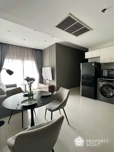 Modern living room with dining area, featuring sleek furniture and appliances, perfect for urban living.