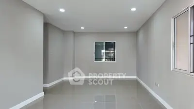 Spacious empty room with modern tile flooring and large window, perfect for customization.