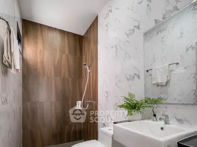 Modern bathroom with elegant marble walls and sleek fixtures, perfect for a luxurious home.