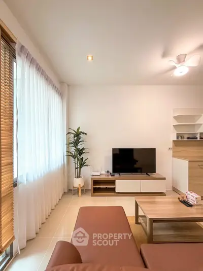 Modern living room with sleek furniture and large window for natural light.