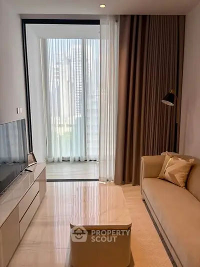 Modern living room with elegant decor and natural light, featuring a cozy sofa and sleek TV setup.