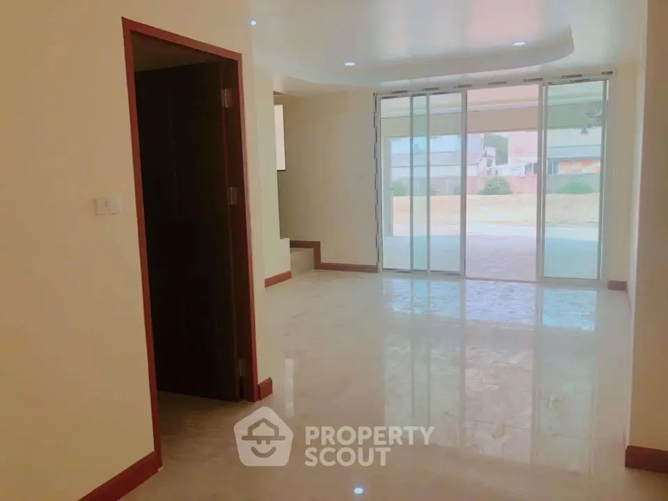 Spacious living room with large glass doors leading to outdoor area, perfect for natural light.