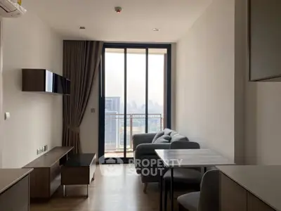 Modern living room with city view, featuring sleek furniture and large windows for natural light.