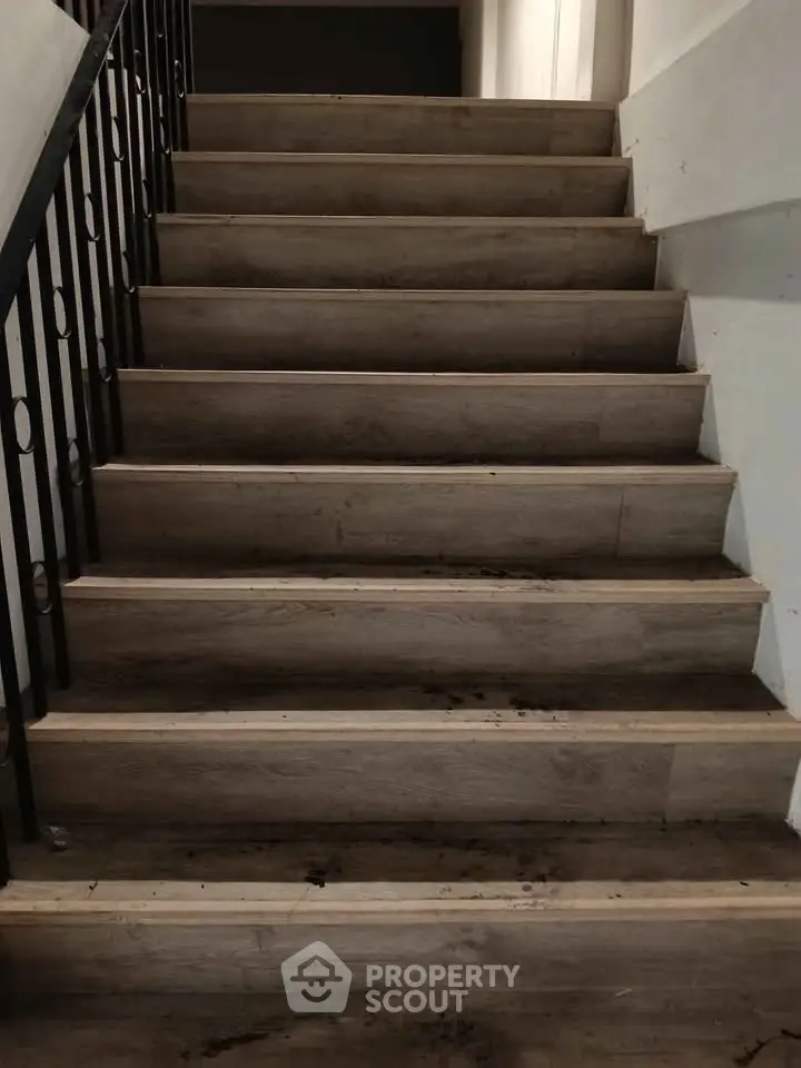 Sturdy wooden staircase with metal railing in a modern building