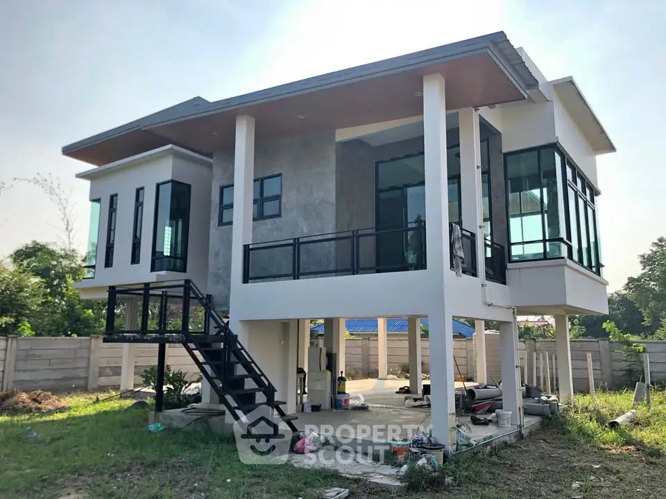 Modern elevated house with large windows and spacious outdoor area