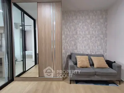 Modern living room with stylish sofa and mirrored wardrobe