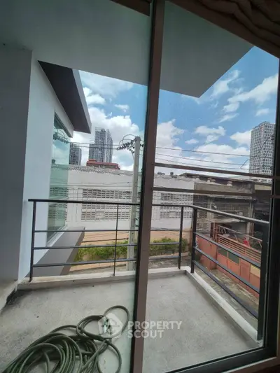 Modern urban balcony with city view and glass railing, perfect for relaxation.