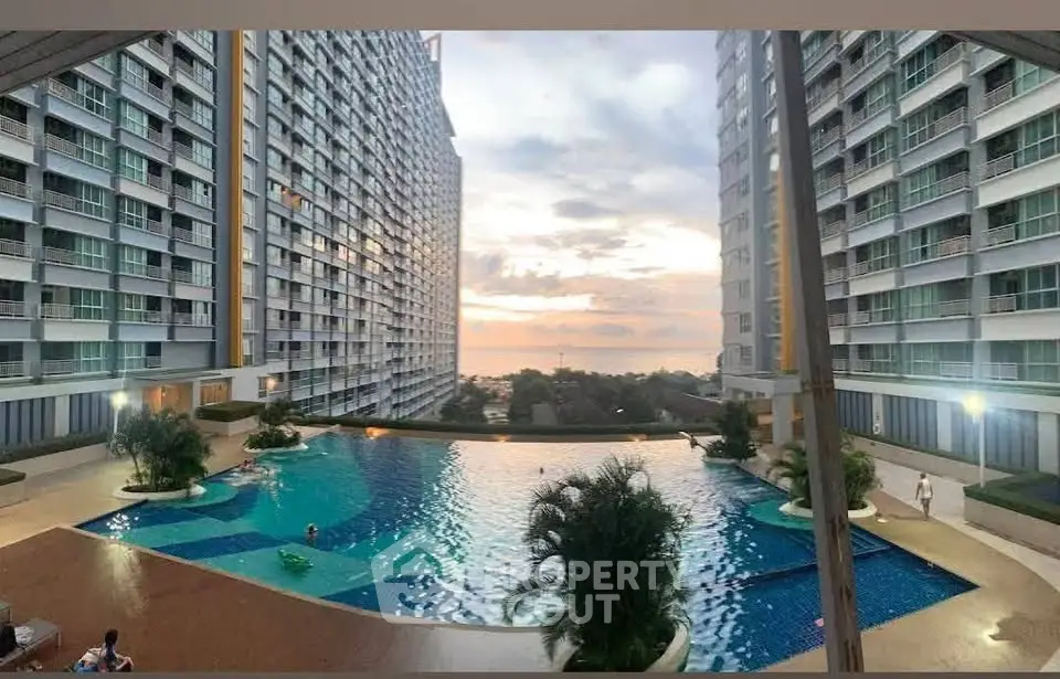 Stunning pool area with sunset view in modern high-rise apartment complex.