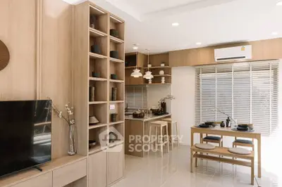 Modern open-plan living room and kitchen with stylish wooden decor and natural light.