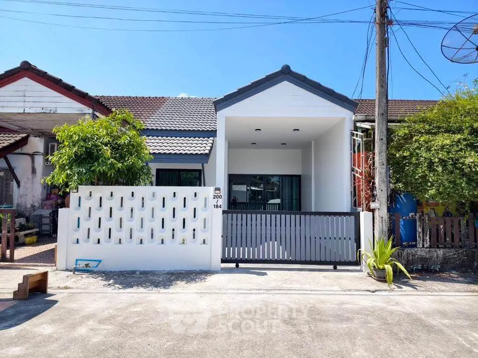 Charming single-story home with modern facade and gated entrance, perfect for cozy living.