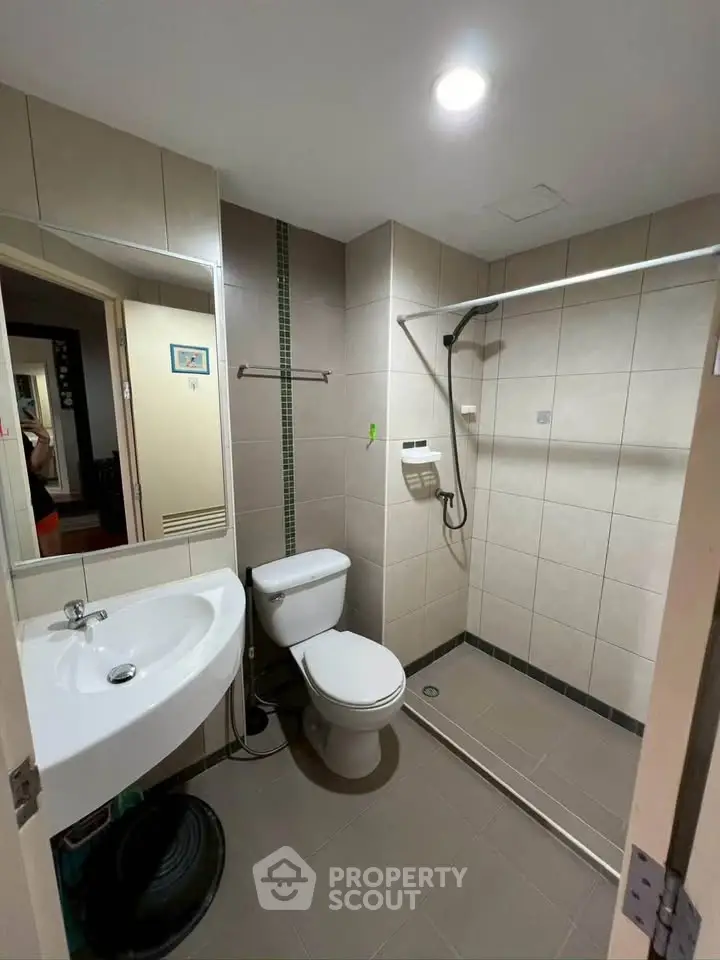 Modern bathroom with walk-in shower and sleek fixtures in a contemporary apartment.