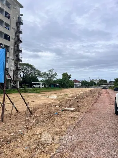 Vacant land with potential for development near residential area and building.