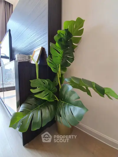 Stylish modern interior with elegant plant decor and sleek wooden furniture, perfect for urban living.