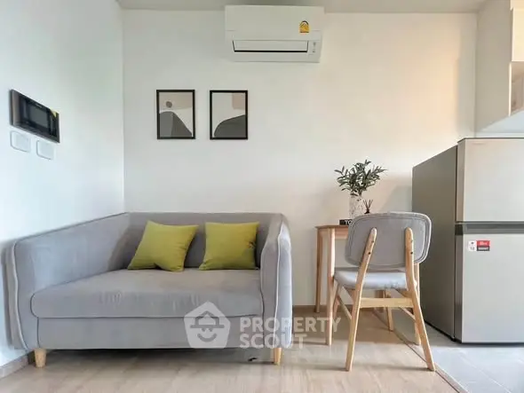 Modern living room with stylish gray sofa, chic decor, and compact dining area, perfect for urban living.