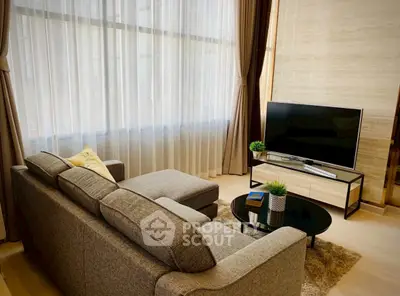 Modern living room with cozy gray sofa and large TV, perfect for relaxation.