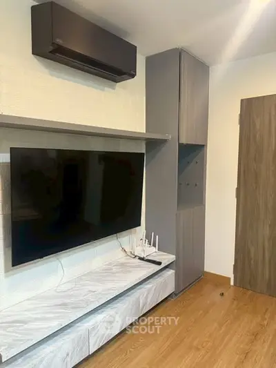 Modern living room with sleek TV setup and stylish storage solutions.