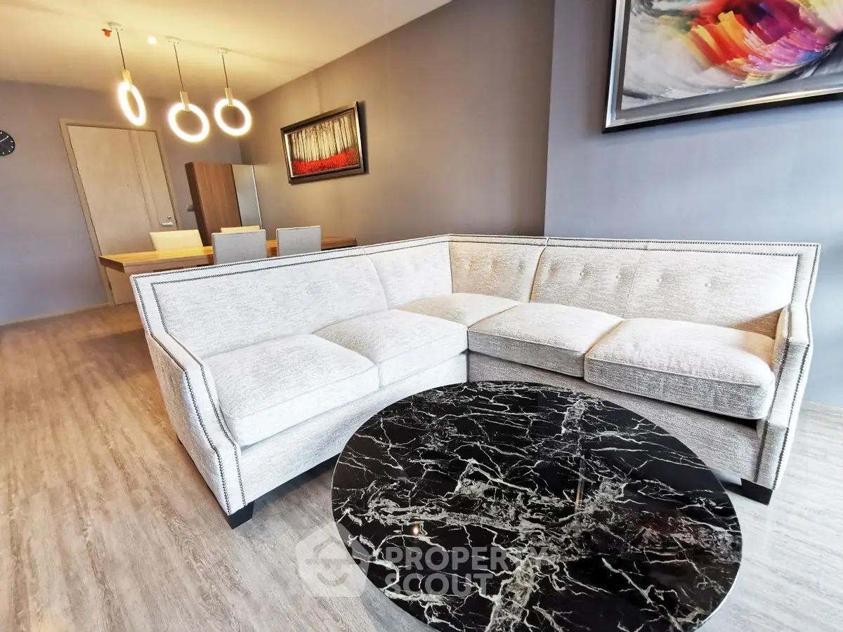 Modern living room with stylish sofa and marble coffee table in open layout apartment.