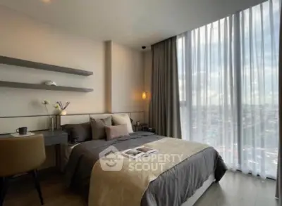 Modern bedroom with floor-to-ceiling windows and city view, featuring stylish decor and cozy ambiance.