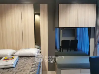 Modern bedroom with stylish wooden furniture and cozy bedding in a contemporary apartment.