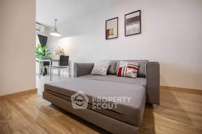 Modern living room with stylish gray sofa bed and elegant decor, perfect for urban living.