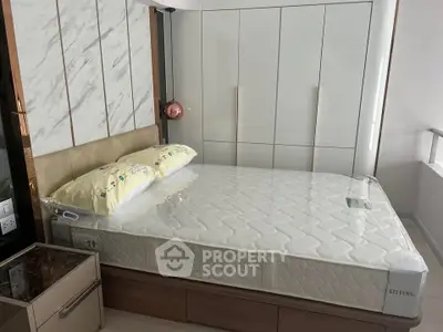 Modern bedroom with stylish bed and built-in wardrobe in a contemporary apartment.
