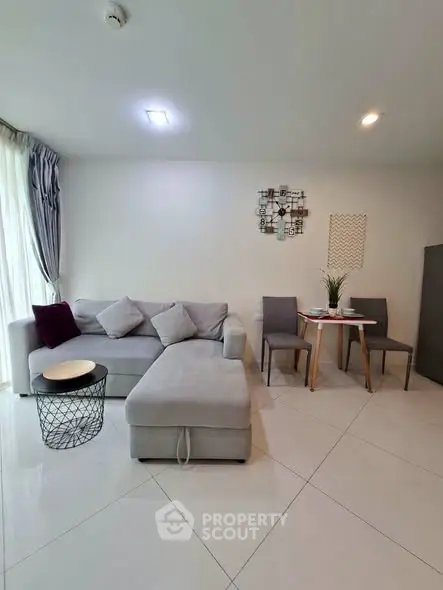 Modern living room with stylish gray sofa and chic dining area, perfect for urban living.