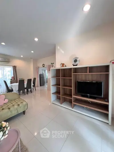 Spacious living room with modern decor and open layout, featuring a cozy dining area and entertainment center.