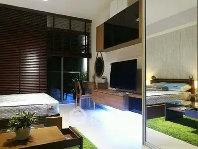 Modern bedroom with stylish decor, large TV, and cozy workspace