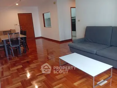 Spacious living room with wooden flooring and modern furniture in a stylish apartment.