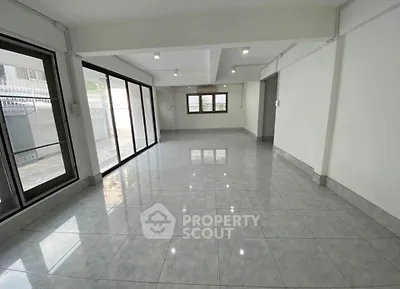 Spacious empty living room with large windows and glossy tiled floor