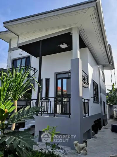 Modern two-story house with sleek design and lush garden