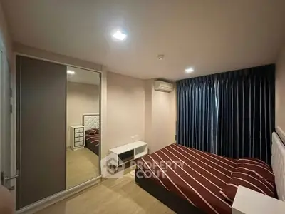 Modern bedroom with stylish decor and mirrored wardrobe in a cozy apartment.