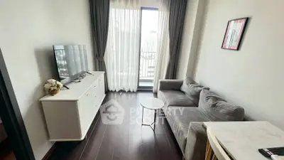 Cozy living room with modern decor and natural light from balcony.