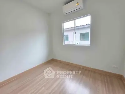 Bright empty room with wooden flooring and air conditioning unit
