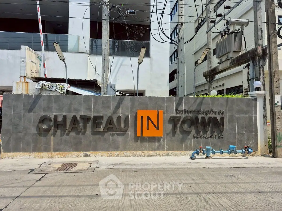 Chateau In Town condominium entrance with modern signage and urban street view.