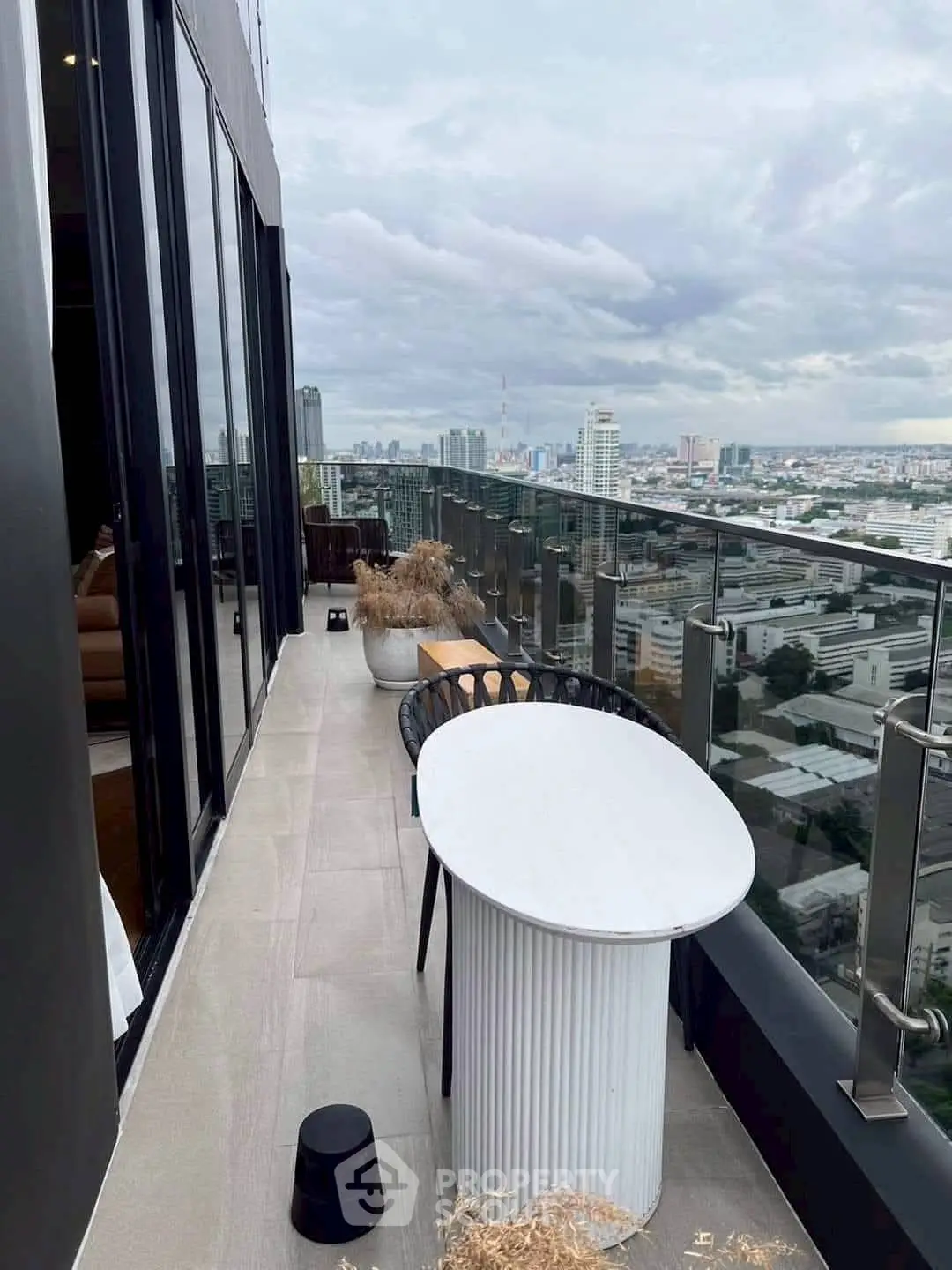 Stunning cityscape view from a modern high-rise balcony with sleek glass railing.